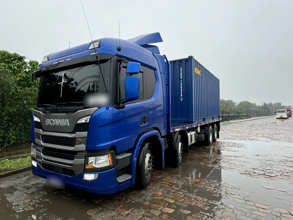 Caminhão Scania transportando contêiner de 20 pés na região do Porto de Santos